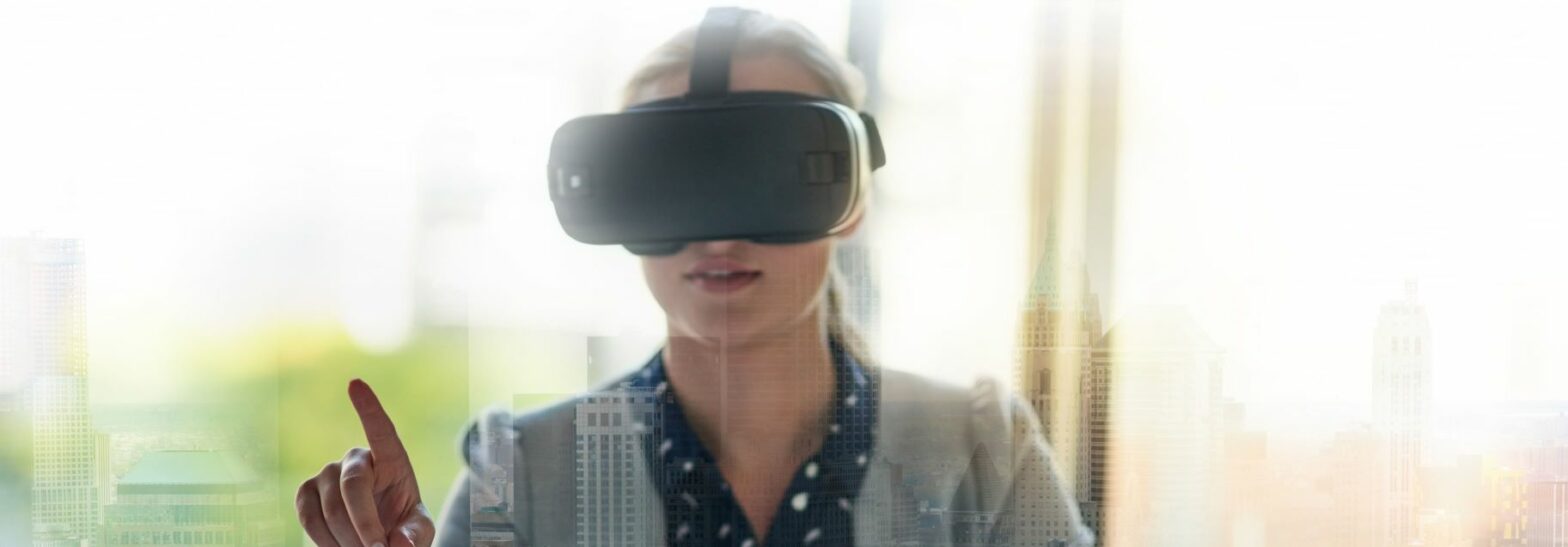Woman in office wearing a VR headset typing on a screen